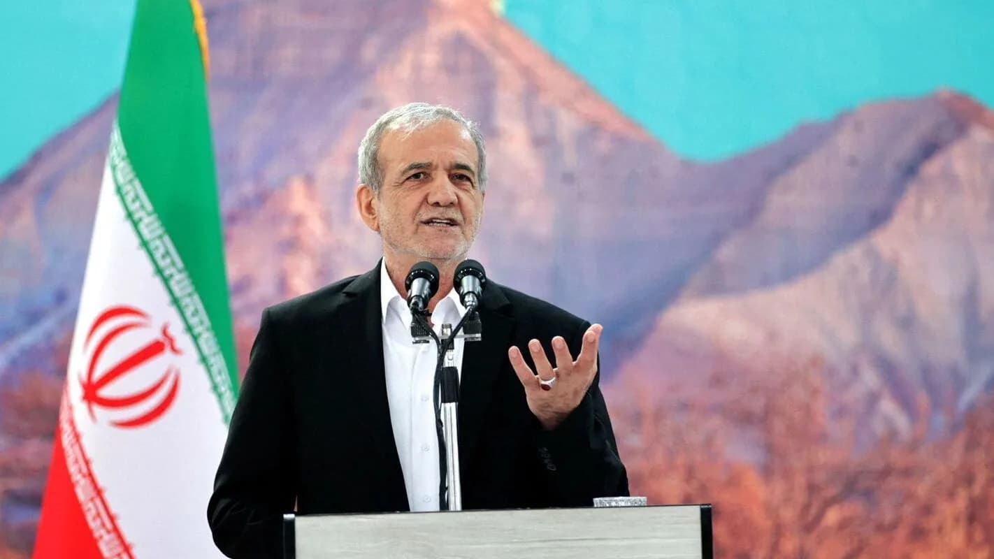 Presidente do Irã, Masoud Pezeshkian, discursa em púlpito com a bandeira do país ao fundo