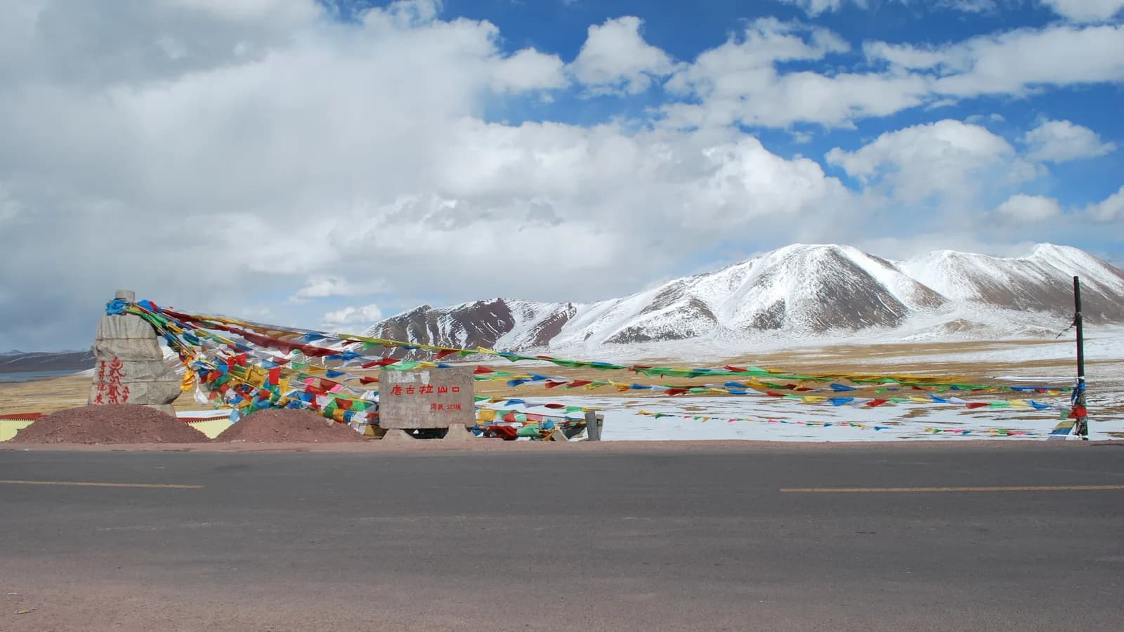 Paisagem montanhosa de Amdo, na região de Nagqu, no Tibete, com bandeiras de oração coloridas em primeiro plano