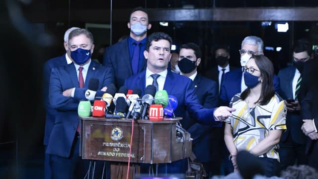 Sergio Moro fala em coletiva de imprensa no Senado Federal, cercado por microfones de emissoras de TV