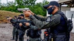 Agentes da Polícia Penal em treinamento tático com armamento, uniformizados