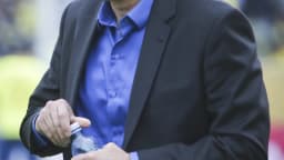 Tite, de terno, à beira do campo durante partida de futebol