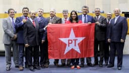 Bancada de vereadores do PT reunida no plenário da Câmara Municipal de São Paulo com bandeira do partido