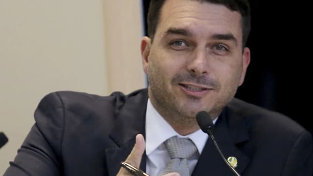 Flávio Bolsonaro fala ao microfone durante audiência no Senado