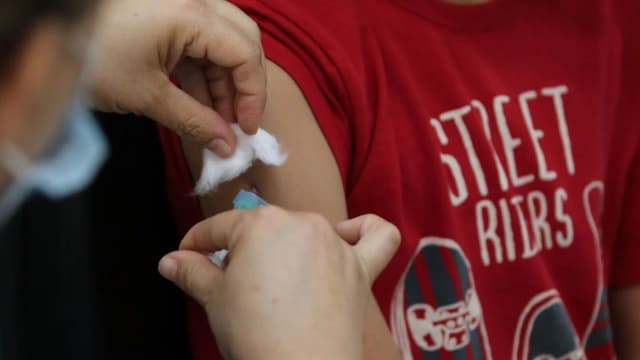 Criança recebe dose de vacina no braço