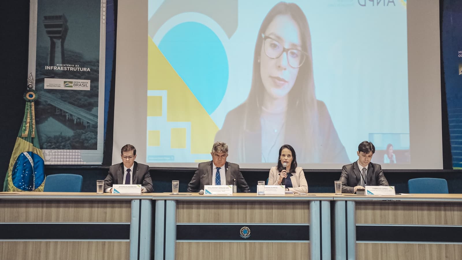 Painel de autoridades em evento sobre proteção de dados pessoais, com logotipo da ANPD ao fundo