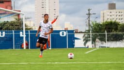 Jogador do Corinthians em partida do sub-20, com o uniforme branco e preto do clube