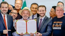 Presidente Lula mostra documento assinado ao lado de ministros e parlamentares no Palácio do Planalto