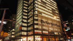 Fachada iluminada da sede do New York Times em Manhattan, à noite