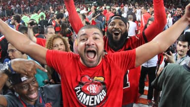 Torcedores do Flamengo comemoram com os braços erguidos nas arquibancadas