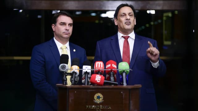 Senador Flávio Bolsonaro fala em entrevista coletiva em frente a microfones de emissoras de TV e rádio