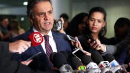 Senador Aécio Neves fala a jornalistas cercado de microfones em coletiva de imprensa