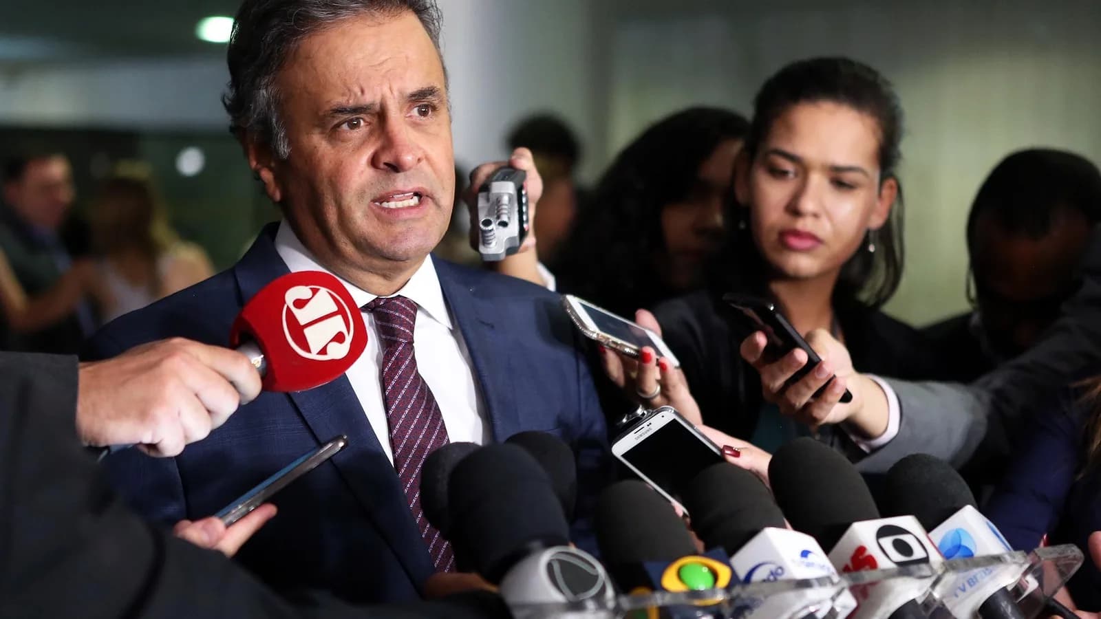 Senador Aécio Neves fala a jornalistas cercado de microfones em coletiva de imprensa