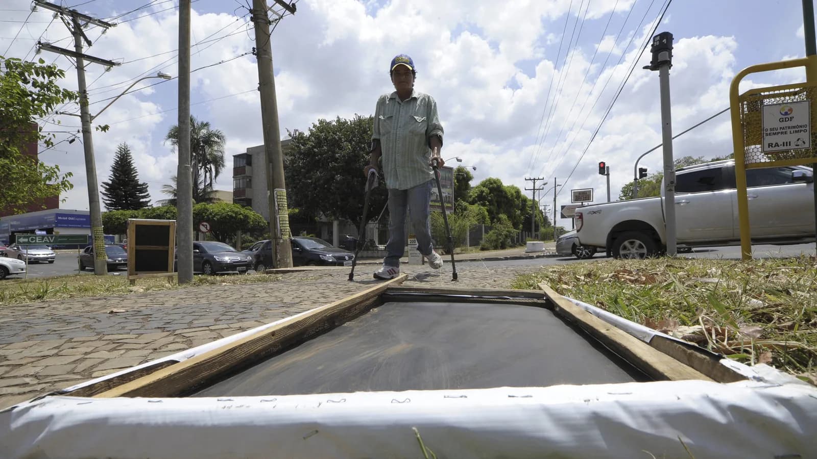 Painel de propaganda eleitoral montado em via pública, com homem ajustando a estrutura