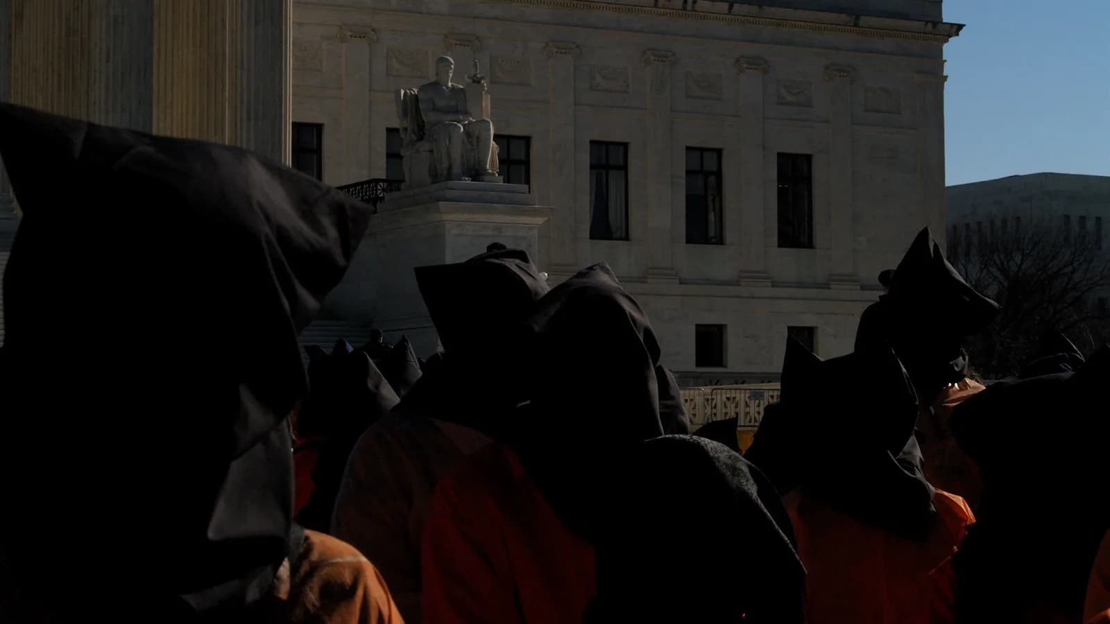Manifestantes usam capuzes pretos e macacões laranja em ato pelo fechamento da prisão de Guantánamo em frente à Suprema Corte dos EUA