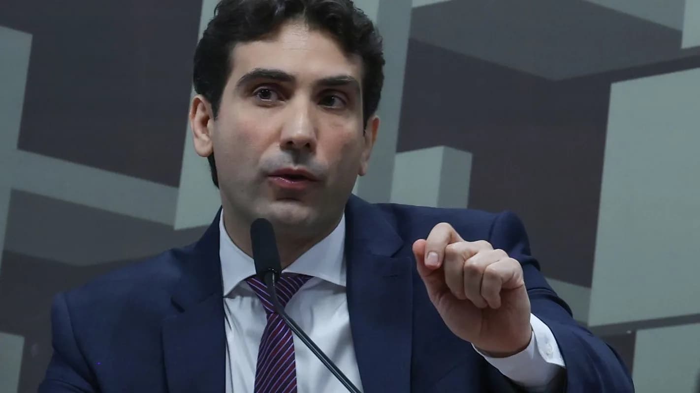 Presidente do Banco Central, Gabriel Galípolo, fala em microfone durante audiência em comissão, gesticulando com a mão