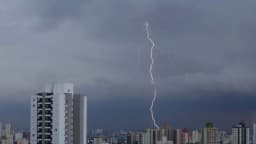 Raio atinge o céu de São Paulo durante tempestade, com prédios da cidade em primeiro plano