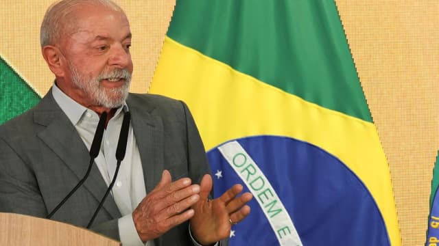 Presidente Luiz Inácio Lula da Silva discursando em frente a uma bandeira do Brasil