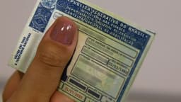 Mão segura carteira nacional de habilitação (foto ilustrativa de trânsito)