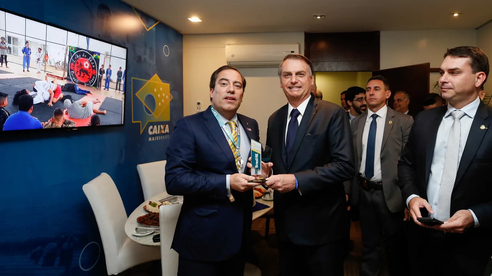 Flávio Bolsonaro ao fundo em evento com o então presidente Jair Bolsonaro, foto de arquivo de 2019