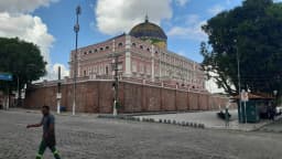 Fachada do Teatro Amazonas, em Manaus, com pedestre passando em frente