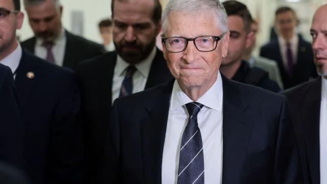 Bill Gates caminha cercado por seguranças durante evento
