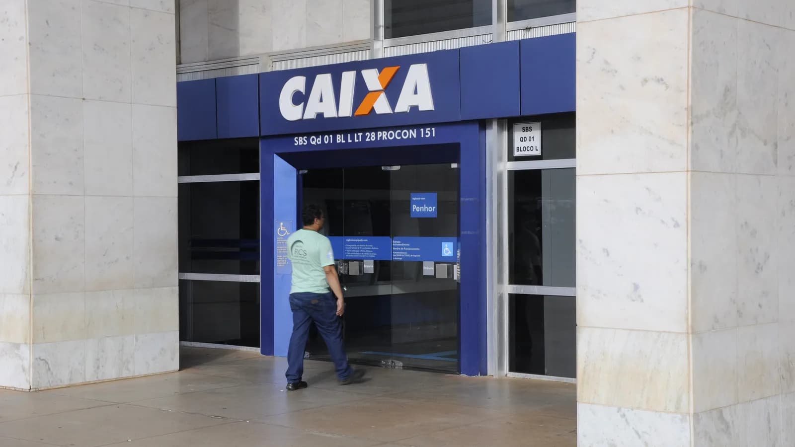 Pessoa entra em agência da Caixa Econômica Federal, banco que seria o executor do Ministério da Prosperidade proposto por Flávio