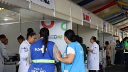 Agentes de saúde atendem público em balcão de serviços públicos ao ar livre