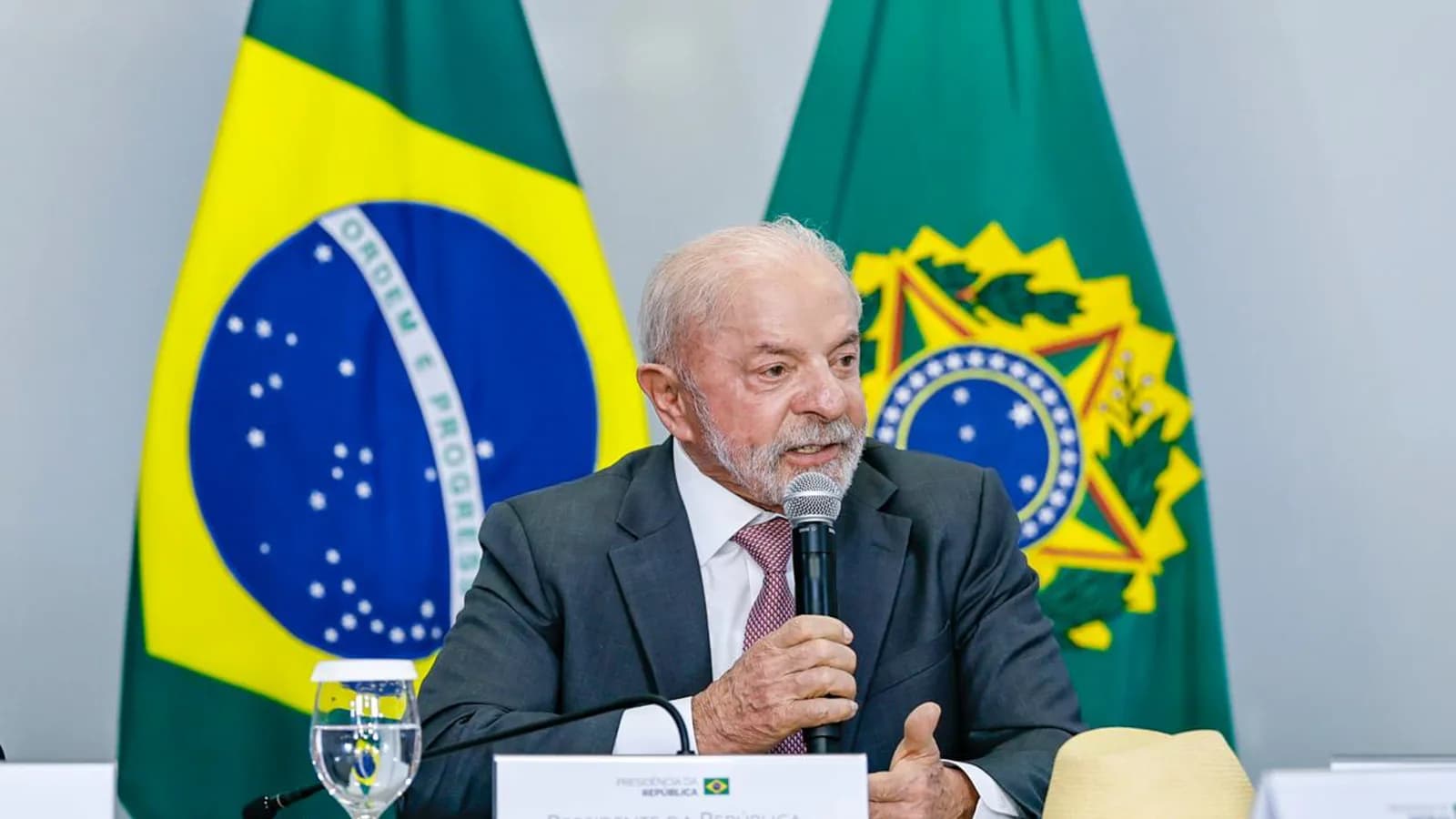 Presidente Lula fala ao microfone em reunião sobre a proibição das bets, com bandeiras do Brasil ao fundo