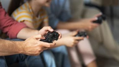 Pessoas seguram controles de videogame em cena de arquivo