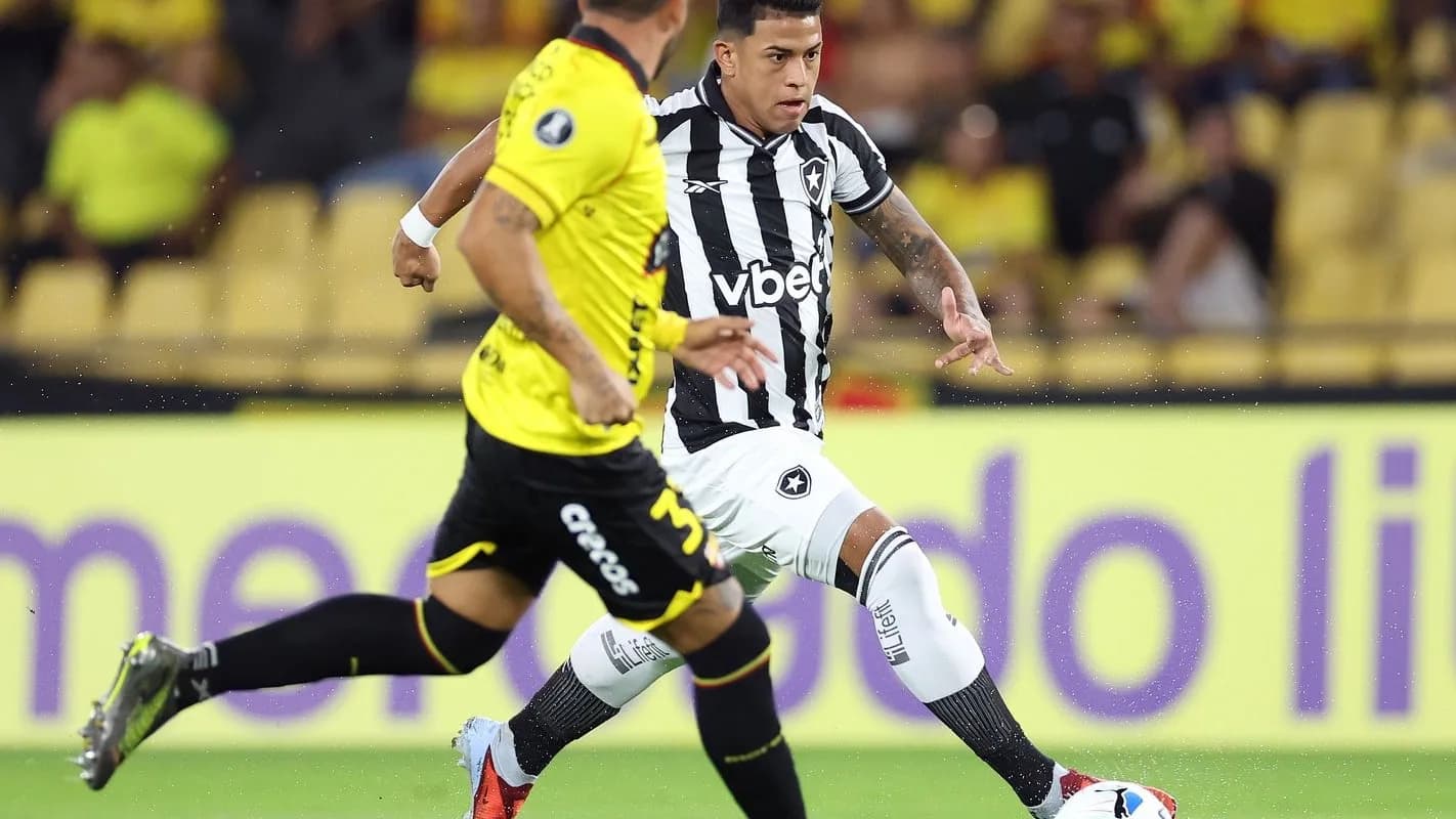 Jogador do Botafogo, de camisa listrada preta e branca, conduz a bola em jogo da Pré-Libertadores em Guayaquil