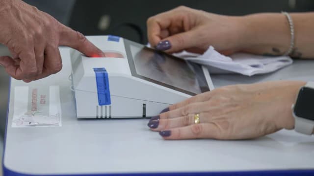 Mãos de eleitora usam urna eletrônica durante votação