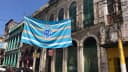 Bandeira do Paysandu, bicolor azul e branca, pendurada na fachada de um prédio histórico