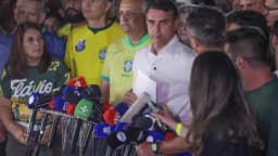Flávio Bolsonaro fala à imprensa cercado de microfones