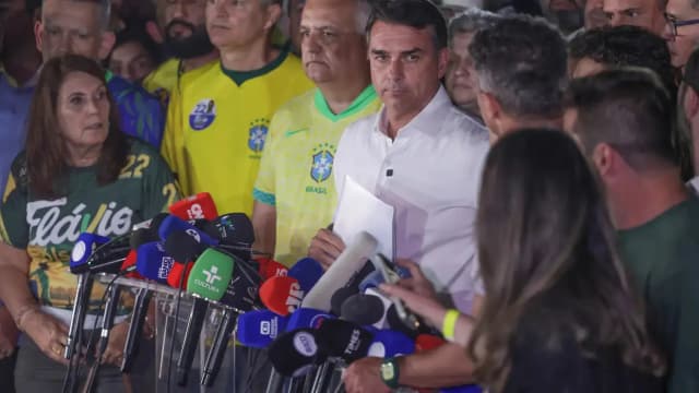 Flávio Bolsonaro fala à imprensa cercado de microfones