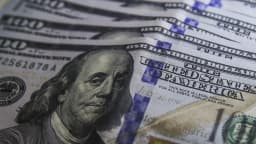 Notas de dólar sendo contadas, ilustrando a reação do câmbio ao cenário eleitoral