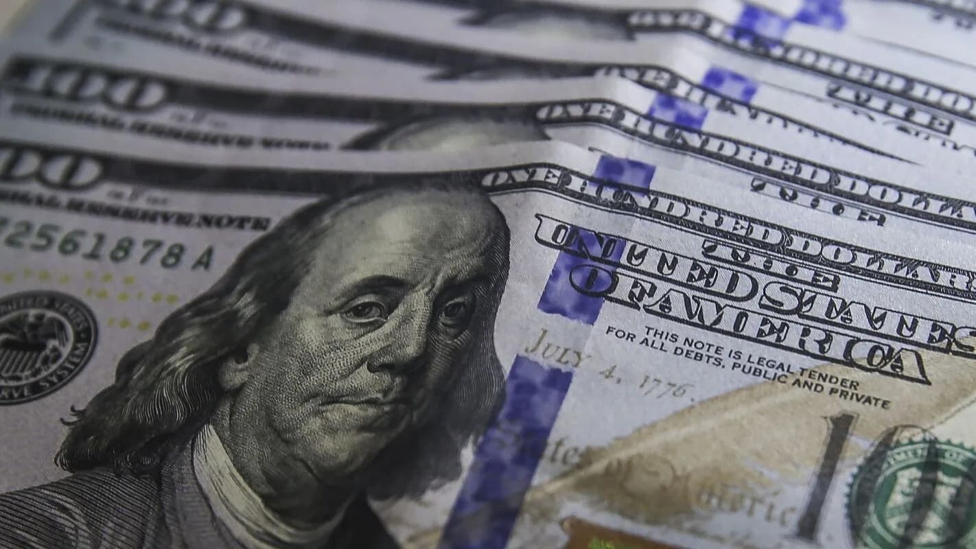 Notas de dólar sendo contadas, ilustrando a reação do câmbio ao cenário eleitoral