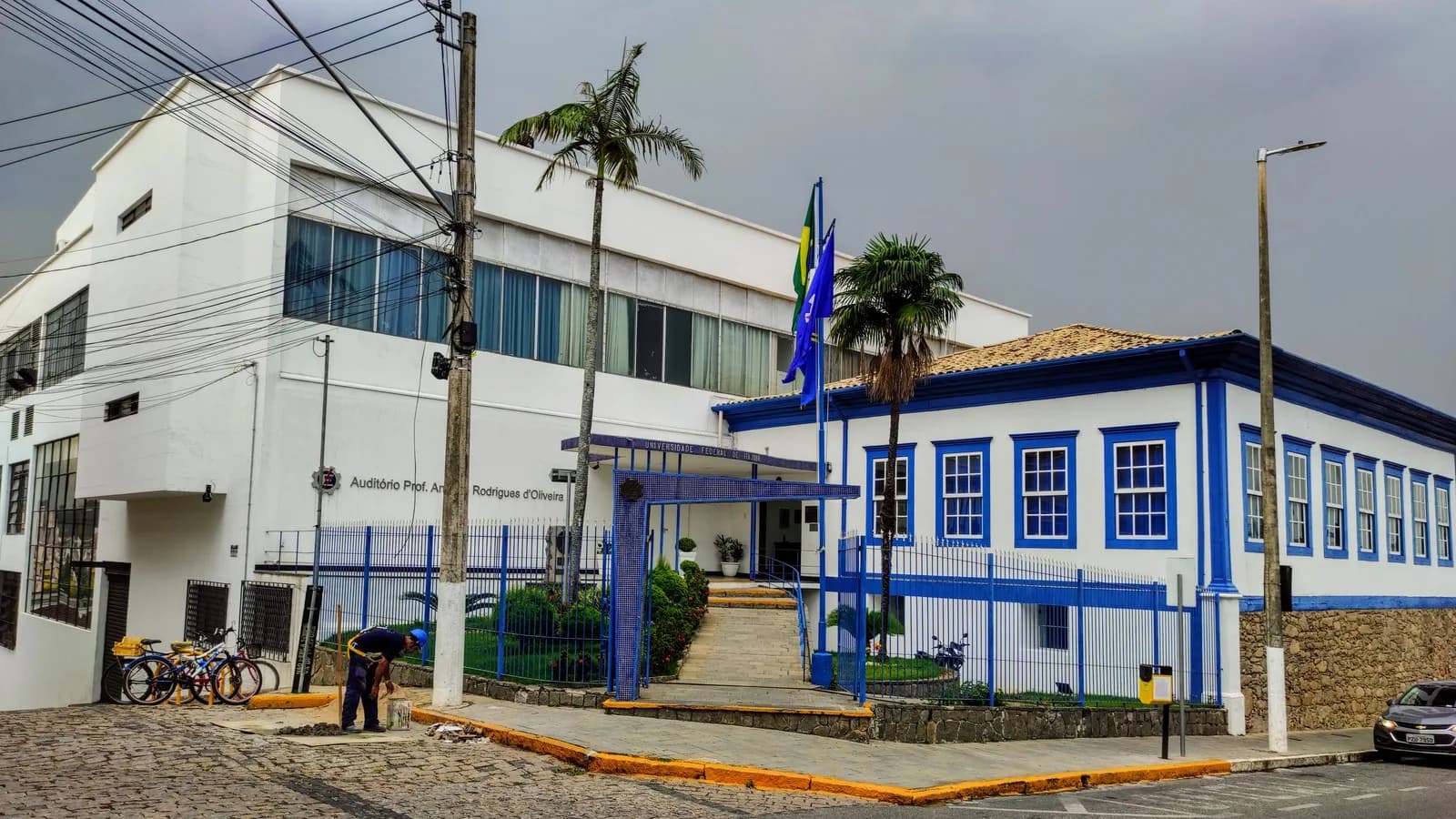 Prédio central da Universidade Federal de Itajubá, com fachada azul e branca e bandeiras hasteadas
