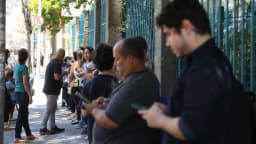 Fila de candidatos aguarda em pé do lado de fora de local de prova de concurso público (foto de arquivo, ilustrativa)