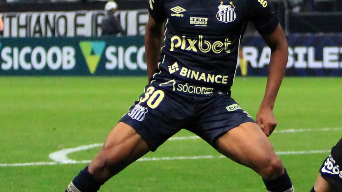 Jogador do Santos em ação durante partida, com uniforme do clube