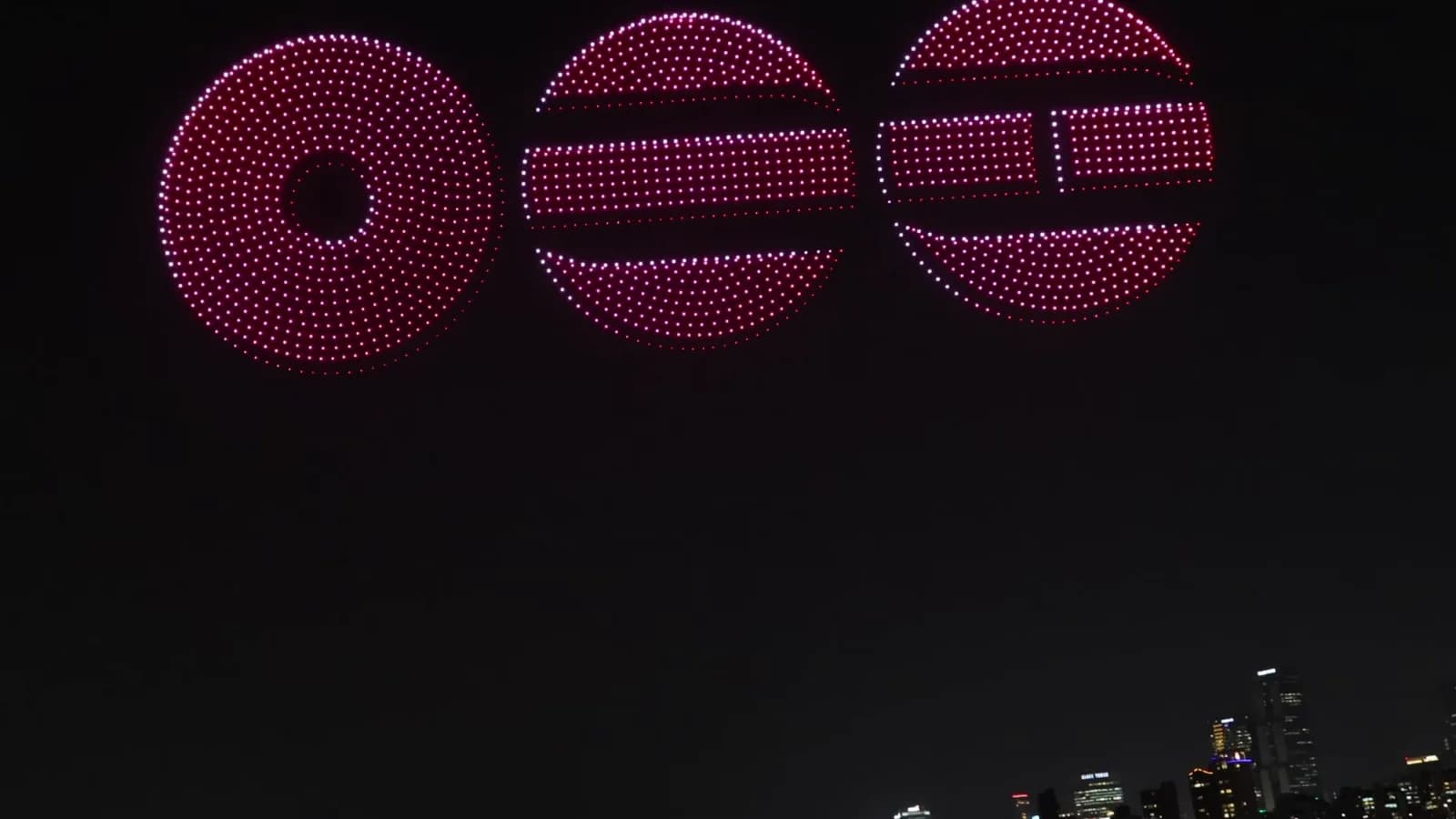 Espetáculo de drones formando figuras luminosas no céu noturno sobre uma cidade (foto ilustrativa, não é do Rock in Rio)