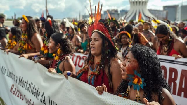 Mulheres indígenas em marcha com faixas em manifestação por direitos (foto de arquivo)