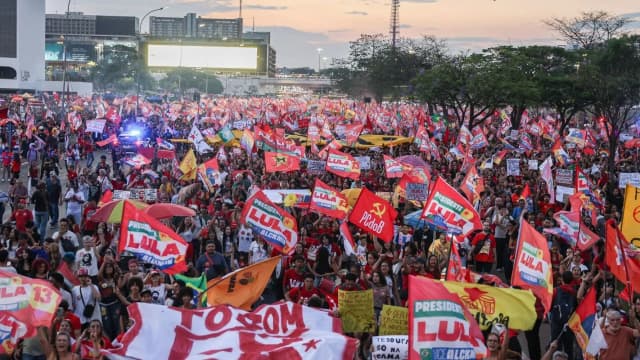 Multidão com bandeiras vermelhas de apoio a Lula tomada na Esplanada dos Ministérios