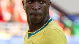 Vinícius Júnior, suado e com expressão séria, durante partida com a camisa amarela da seleção brasileira