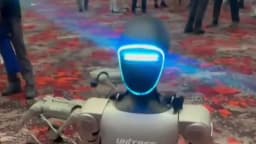 Robô humanoide da Unitree em pé em feira, com pessoas ao fundo