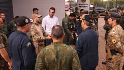 Agentes da Polícia Federal e militares reunidos em frente à sede da corporação
