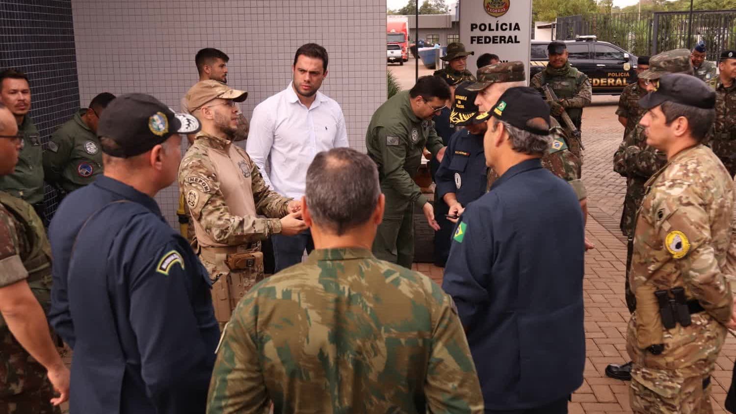 Agentes da Polícia Federal e militares reunidos em frente à sede da corporação