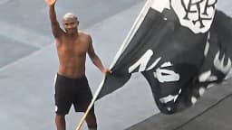 O lateral Cuiabano acena para a torcida do Botafogo segurando uma bandeira do clube no Nilton Santos