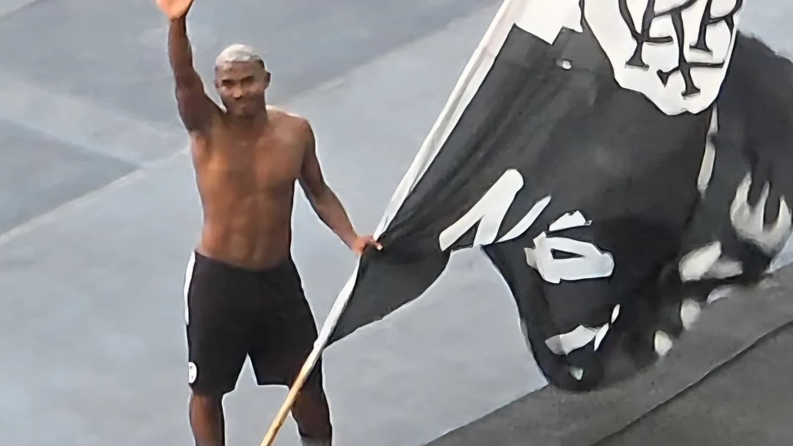 O lateral Cuiabano acena para a torcida do Botafogo segurando uma bandeira do clube no Nilton Santos
