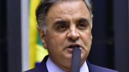 Aécio Neves discursa em plenário com bandeira do Brasil ao fundo