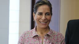 Glória Pires sorri em evento público, vestindo camisa estampada
